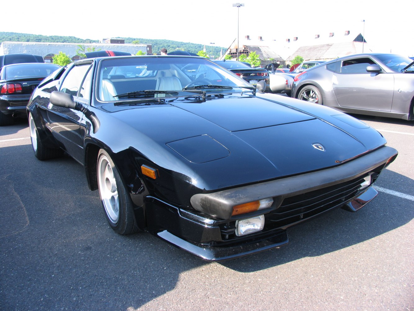 Black classic sports car with pop-up headlights and wide body design