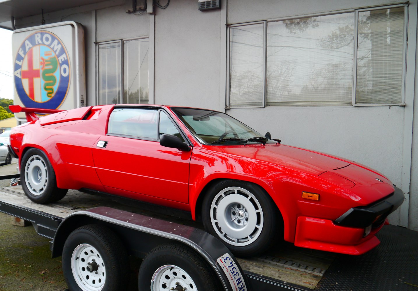 Red classic sports coupe with angular design and rear spoiler.