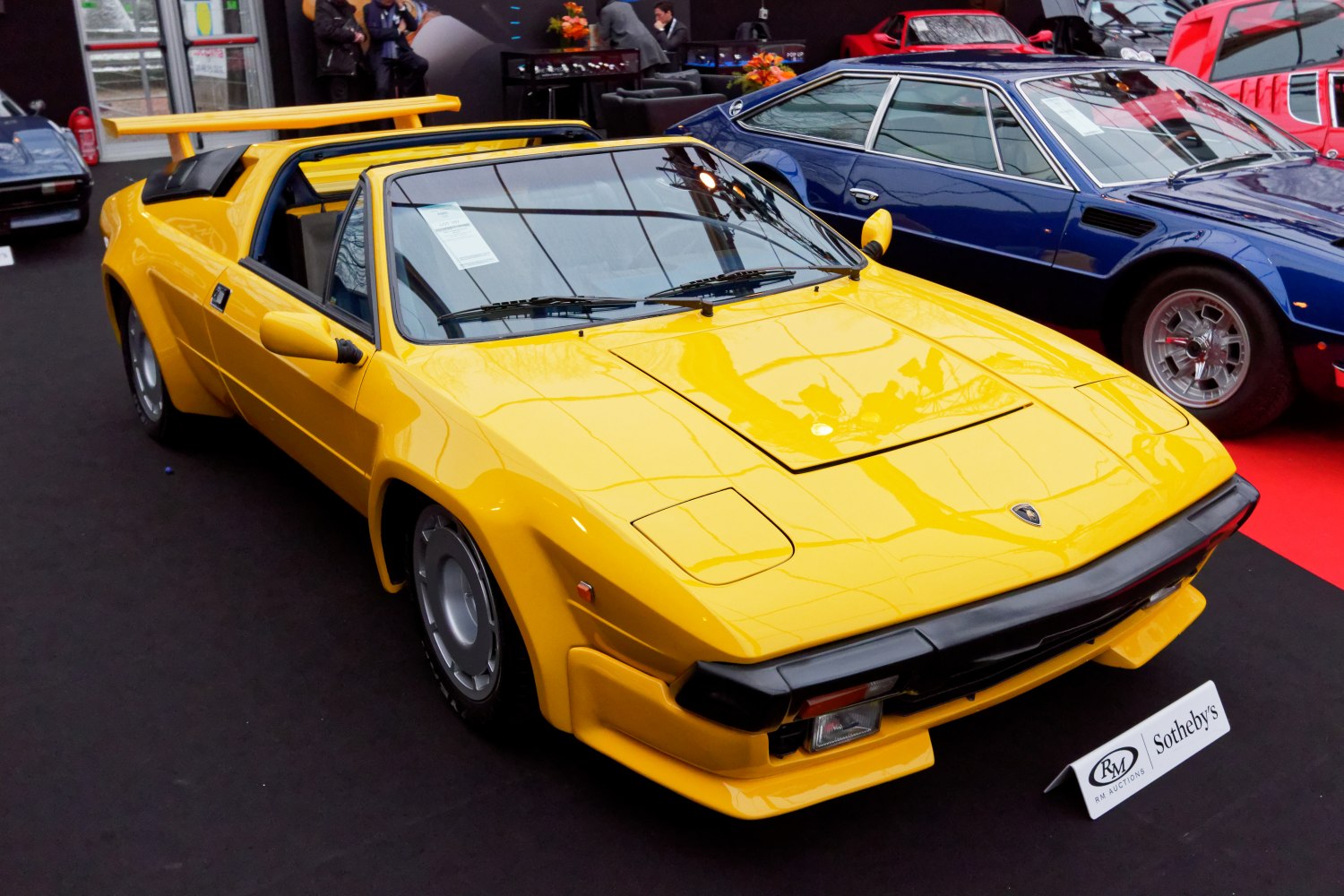 Yellow convertible sports car with rear wing and pop-up headlights