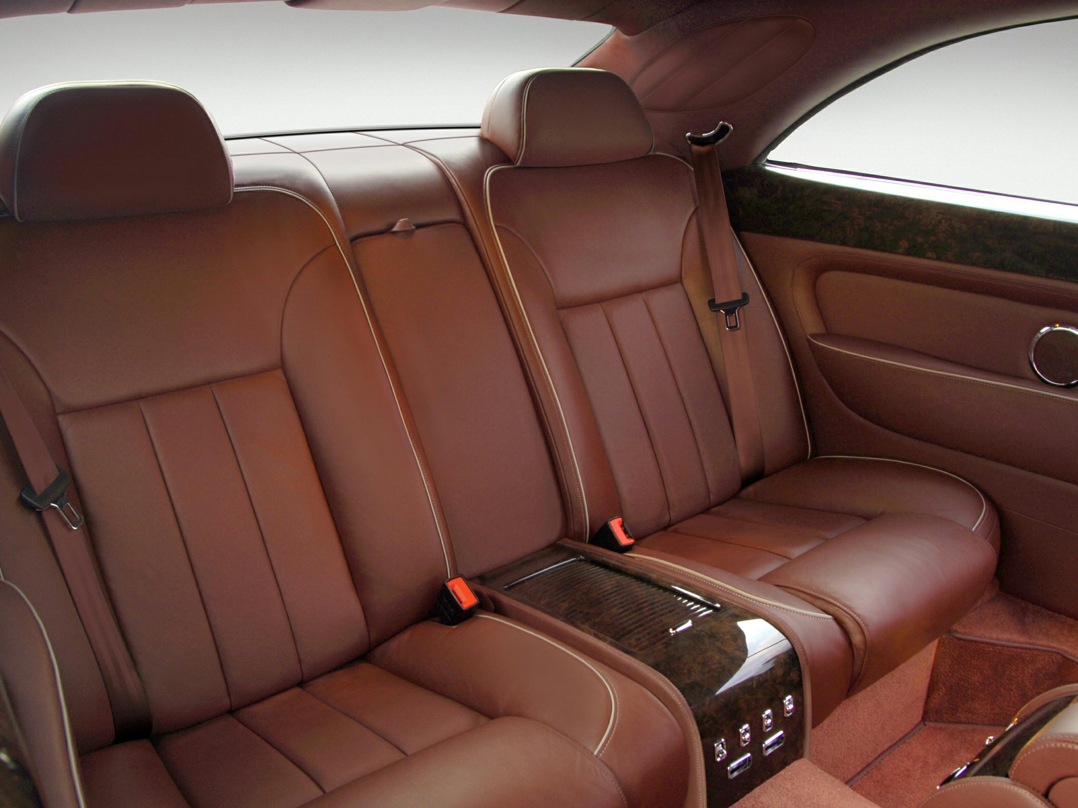 Brown leather rear seats with wood trim and integrated controls