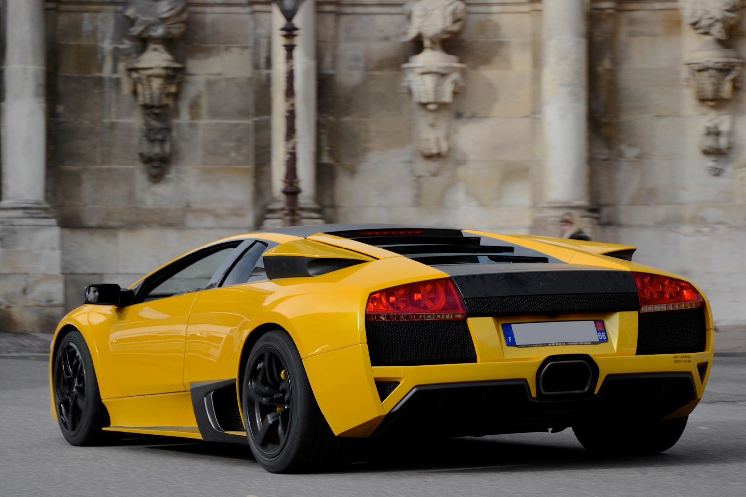 Rear view of mid-engine sports car with aerodynamic design and black accents