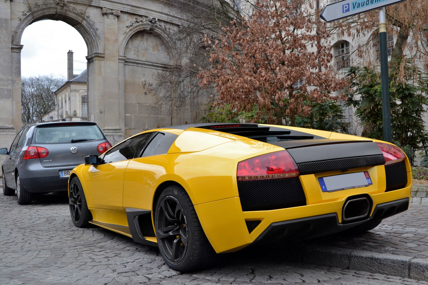 Yellow sports car rear with black rims and distinct taillights