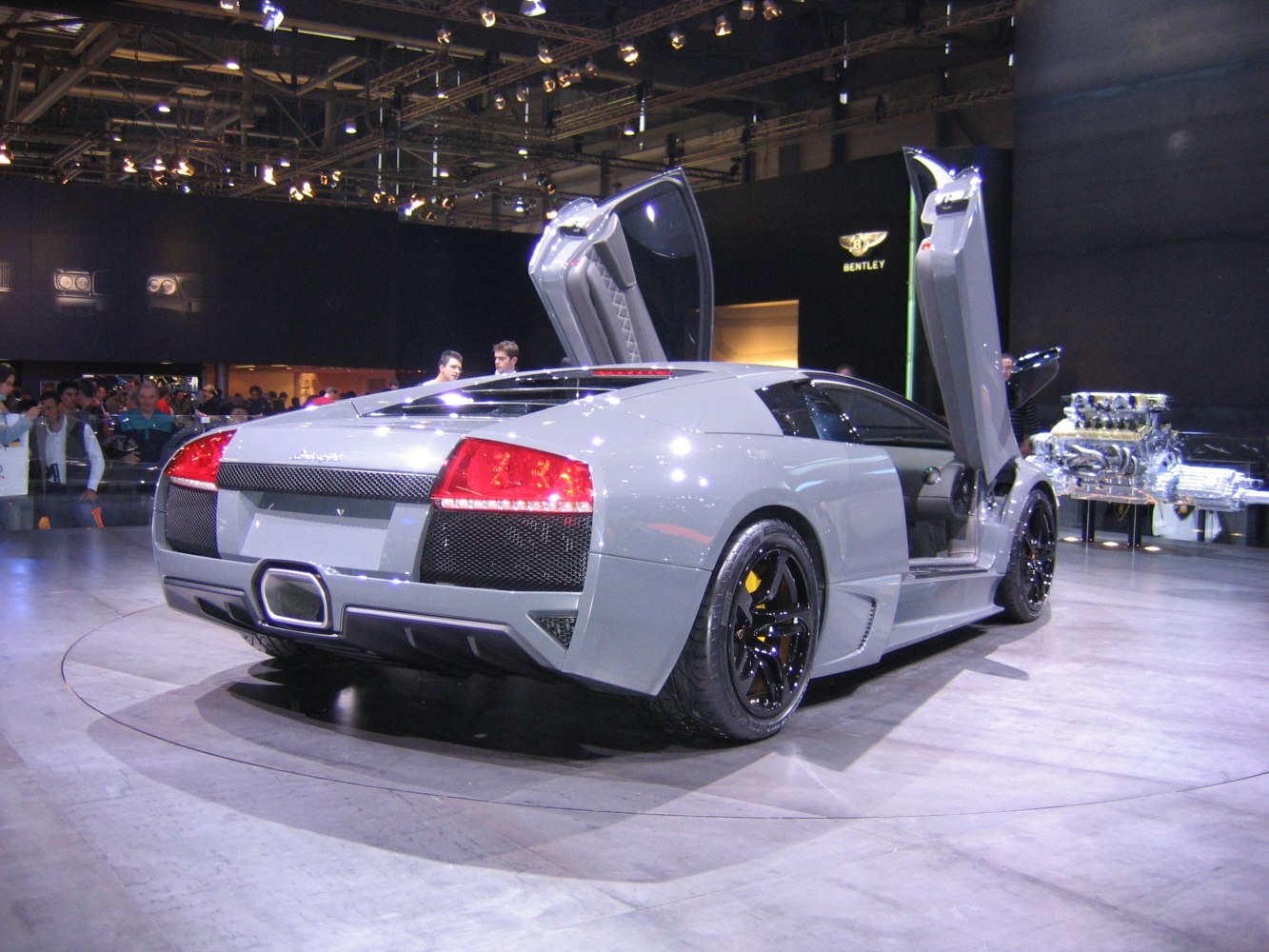 Rear view of a sports car with scissor doors open.
