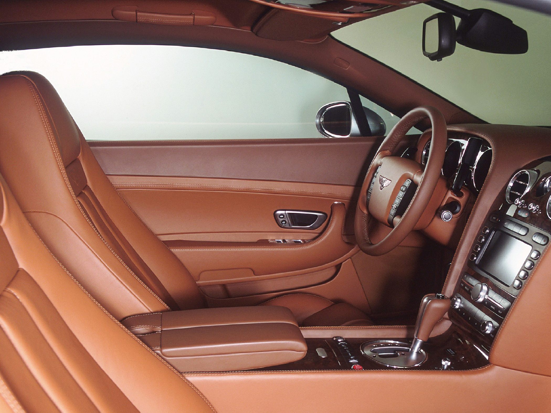 Brown leather interior with wood trim and detailed dashboard