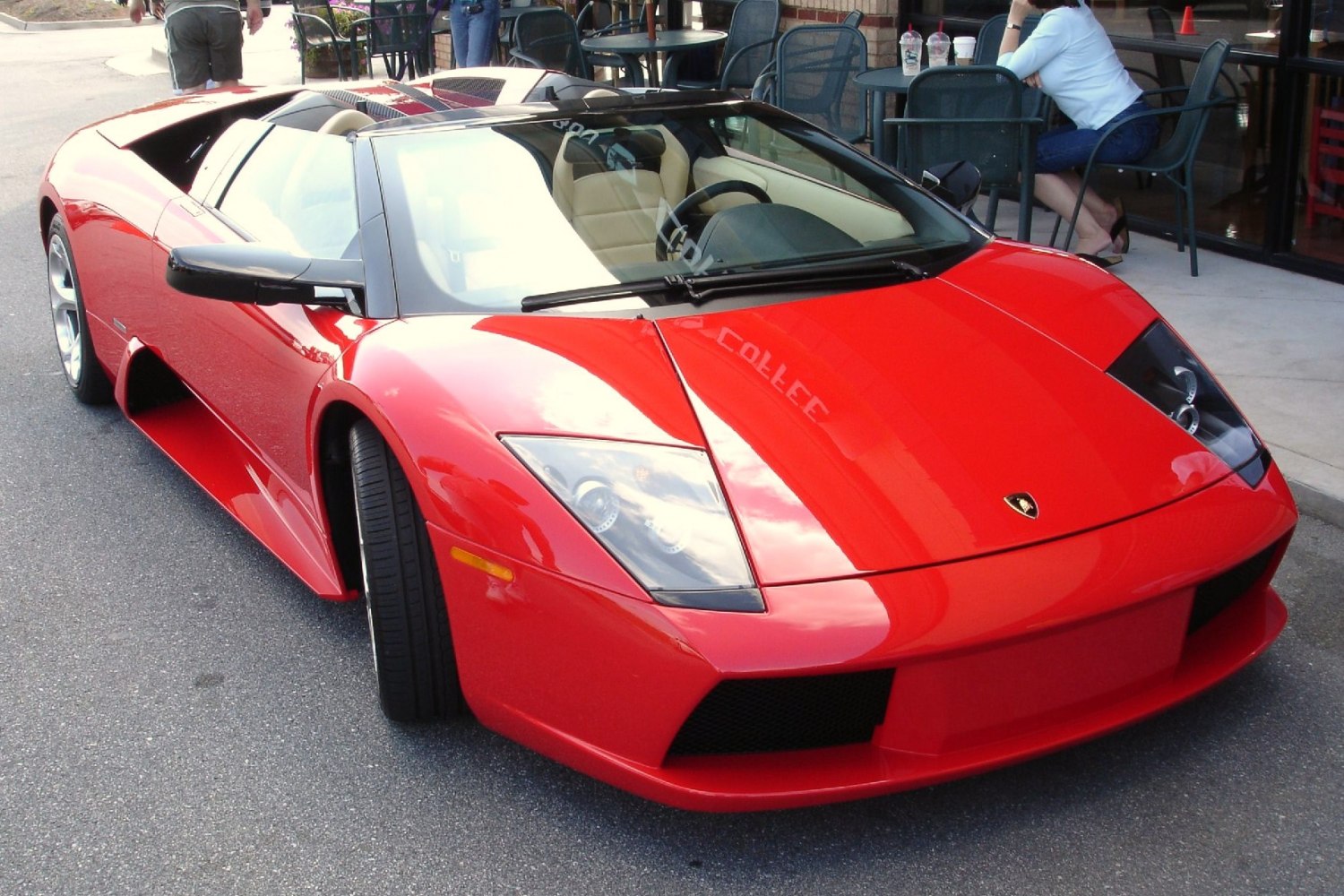 Red convertible sports car front with sleek headlights and aerodynamic bonnet