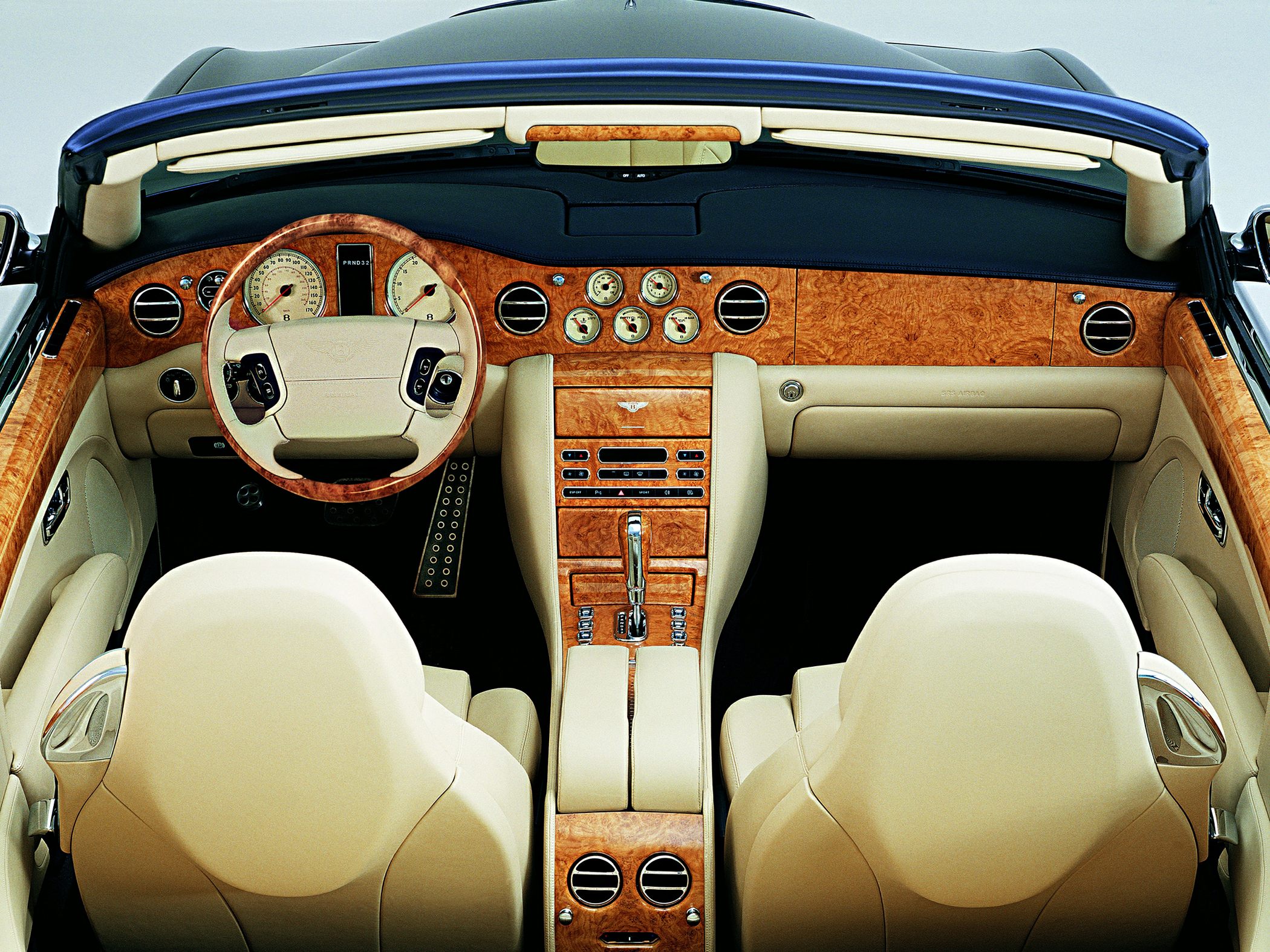 Wooden dashboard and beige leather seats in luxury convertible interior
