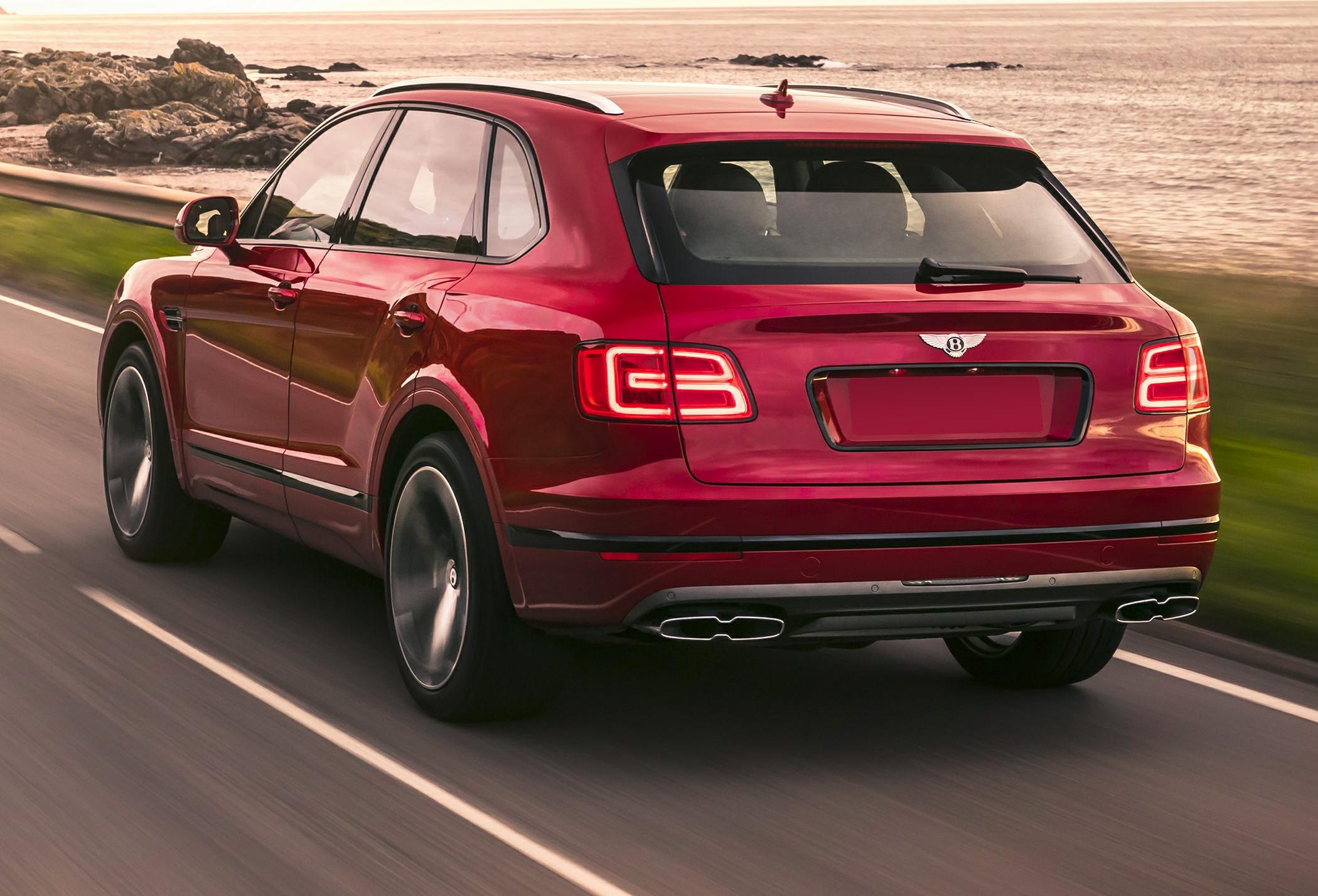 Luxury SUV rear with LED tail lights and dual exhaust on coastal road