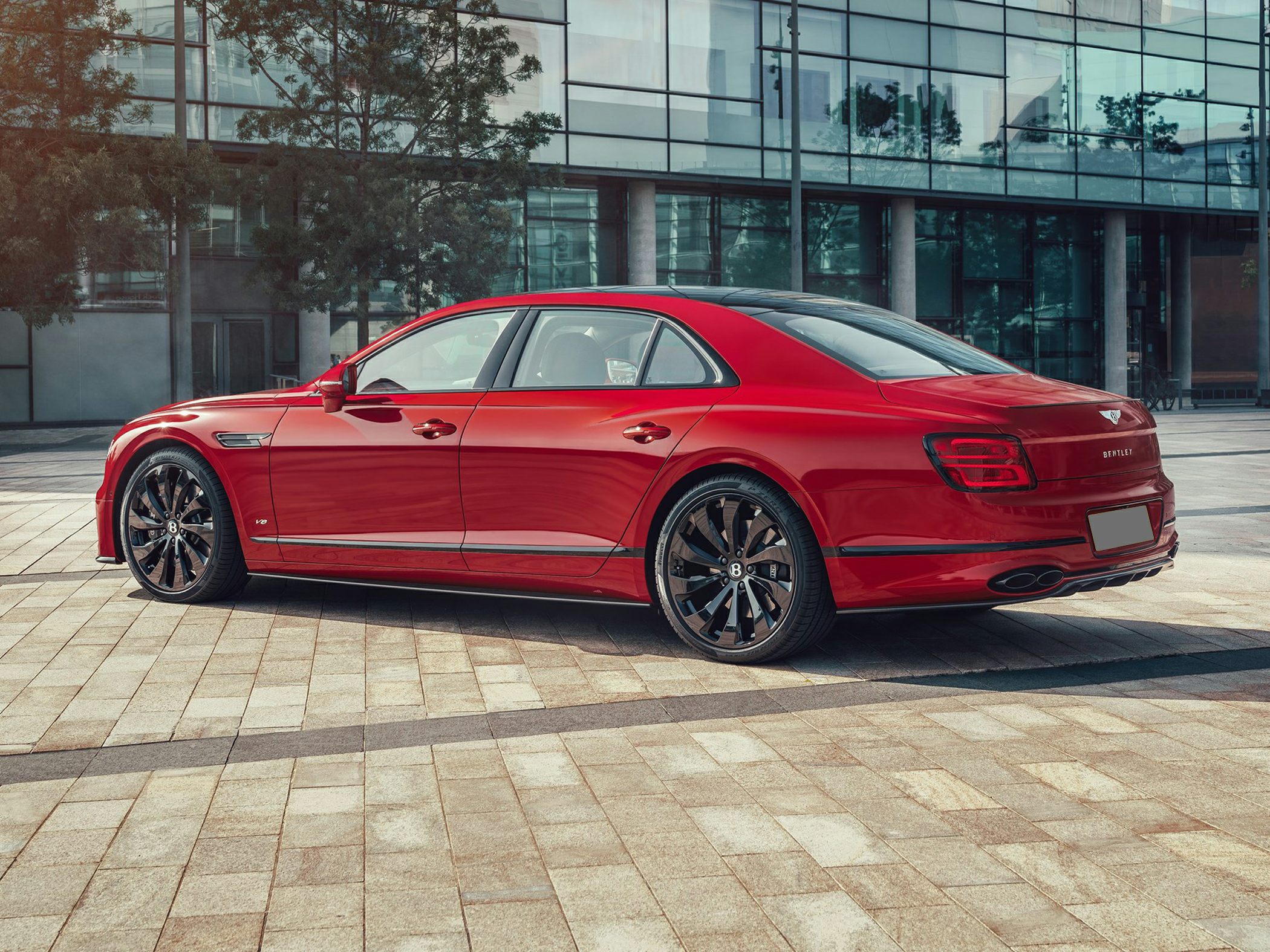 Red luxury sports sedan rear with alloy wheels and sleek silhouette
