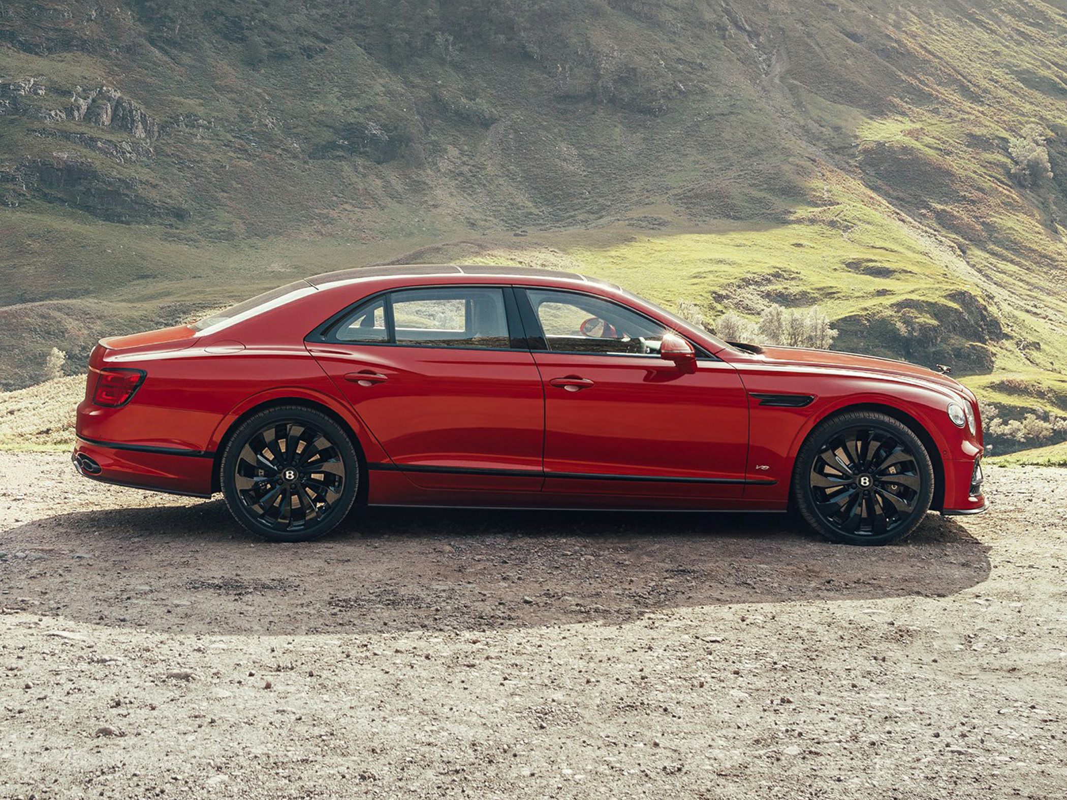 Luxury sedan side profile with sleek lines and distinctive black alloy wheels