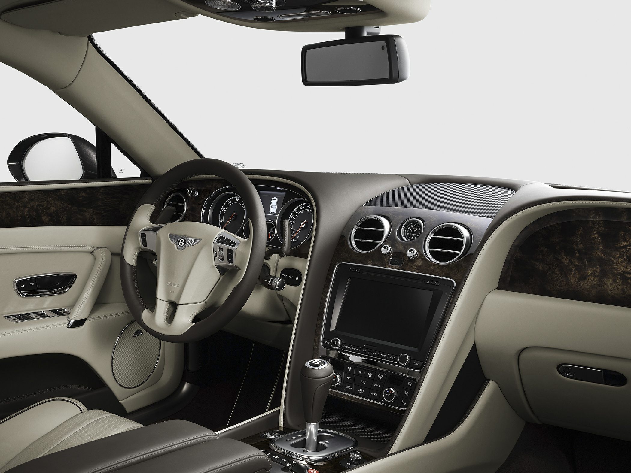 Luxury steering wheel, dashboard, wood trim, and leather interior details