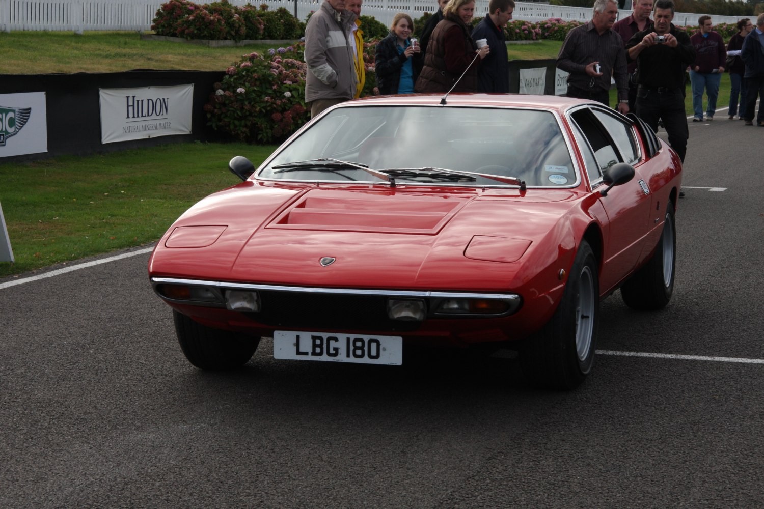Red sports coupe with pop-up headlights and rear window louvers
