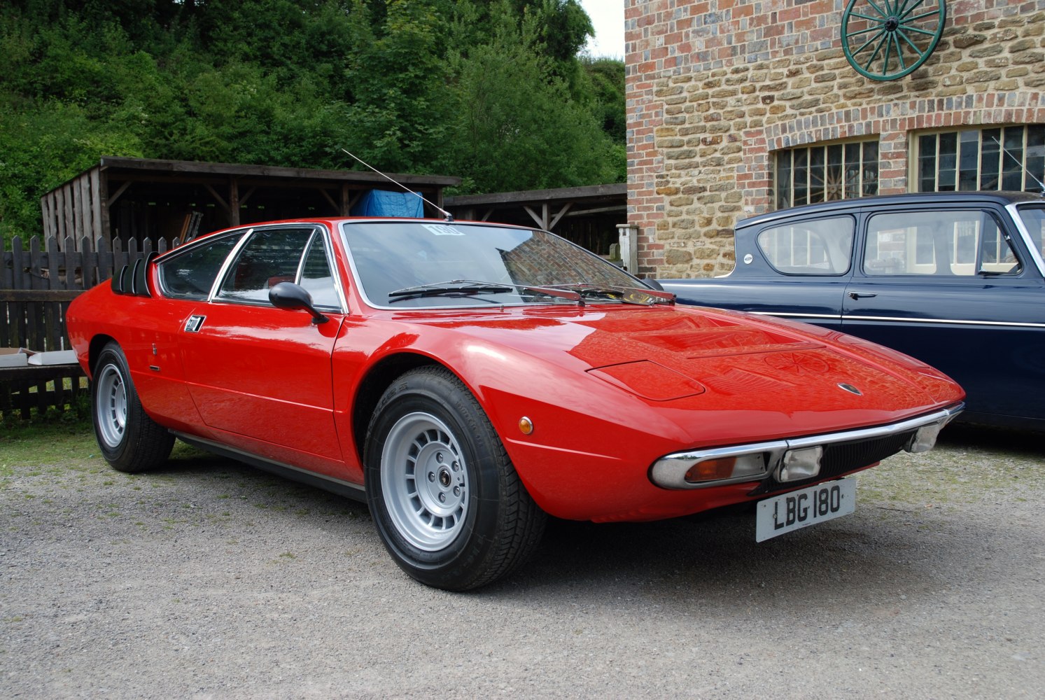 Vintage red sports coupe with wedge shape and rear window louvers