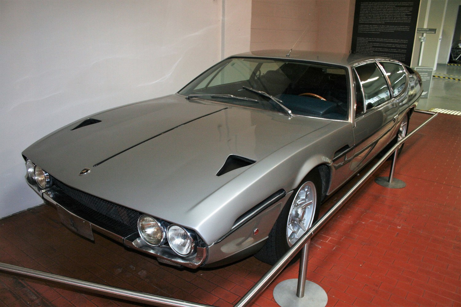 Vintage silver sports coupe with quad headlights and hood vents