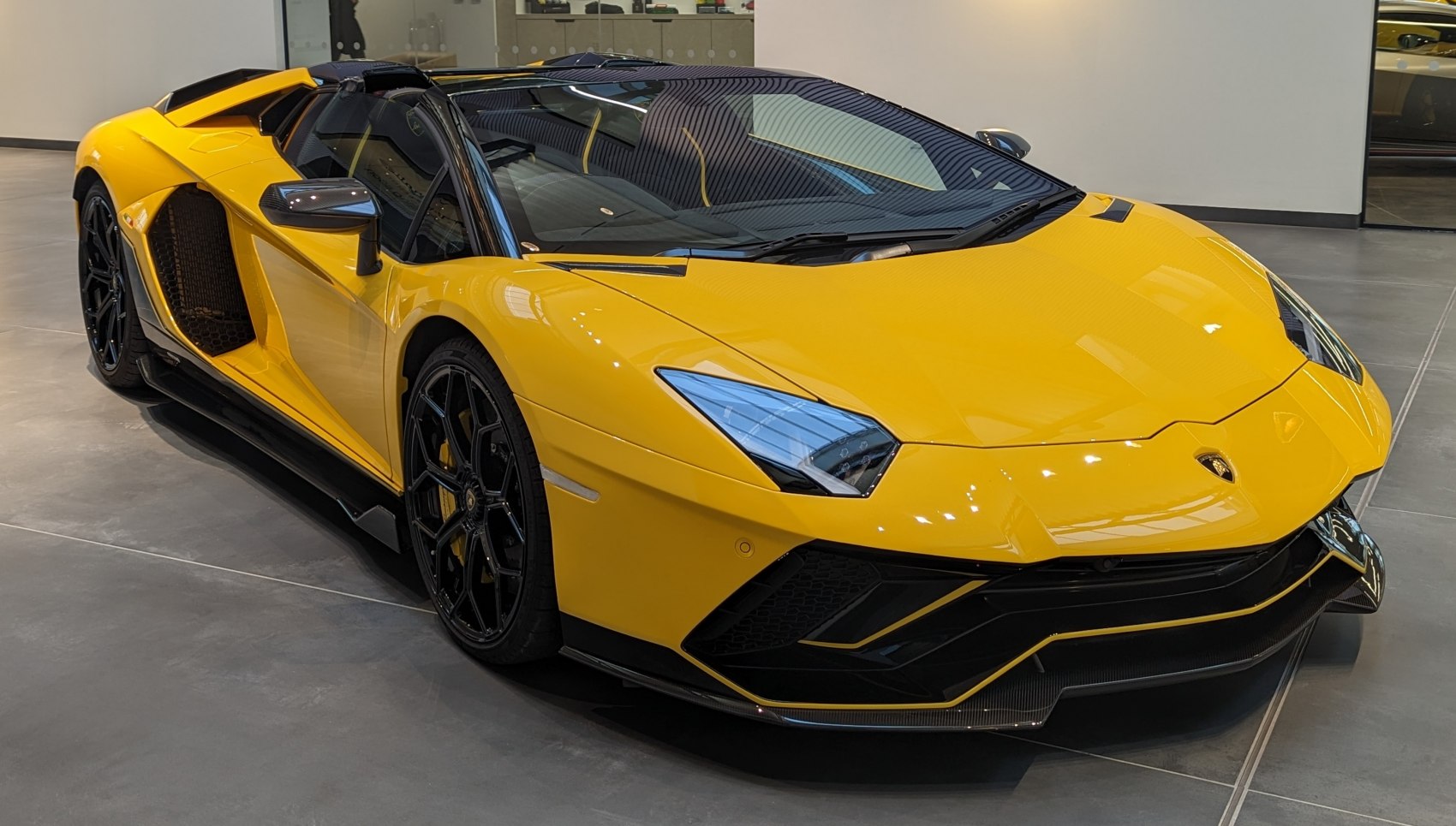 Yellow supercar with sharp angular headlights and black wheels
