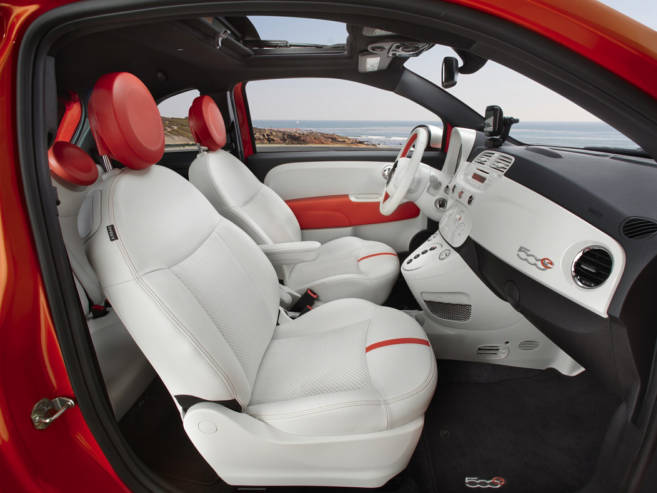 White leather seats and dashboard with red accents in a compact car interior