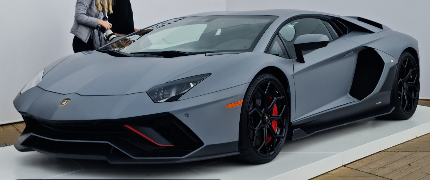 Matte grey sports coupe with sharp headlights and black multi-spoke wheels