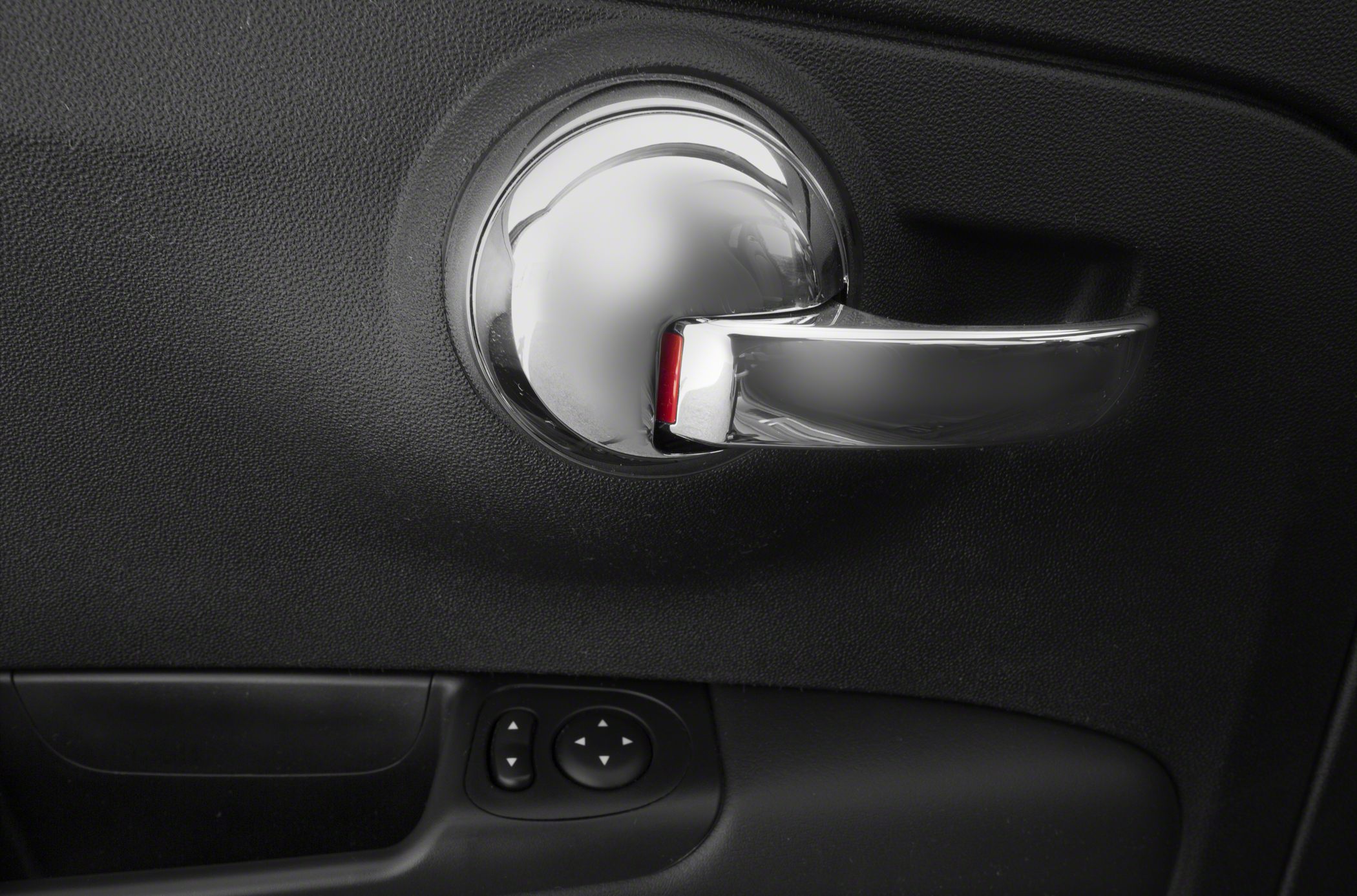 Chrome door handle and window control buttons on textured interior panel