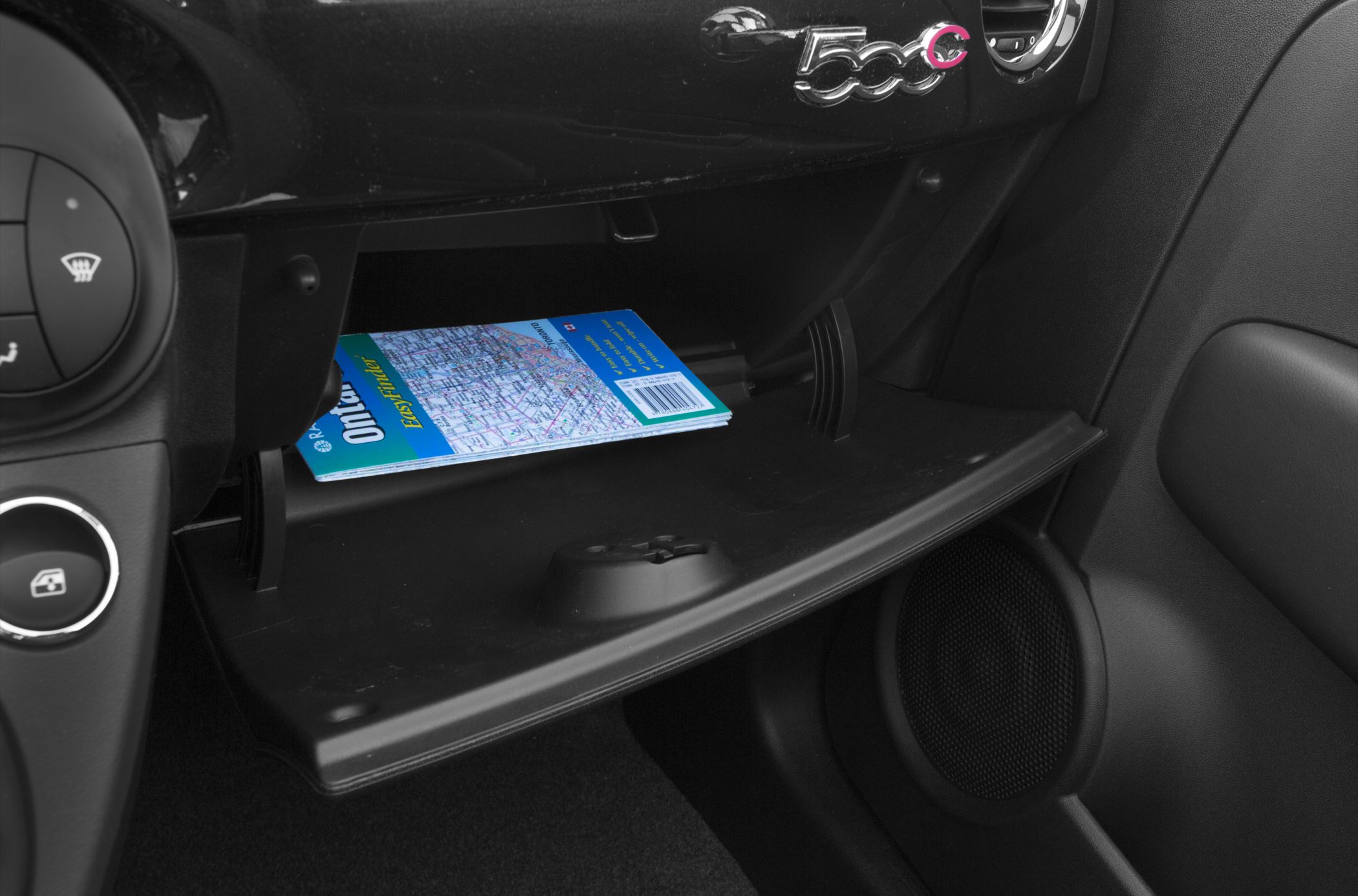 Open glove box storage with a folded map inside