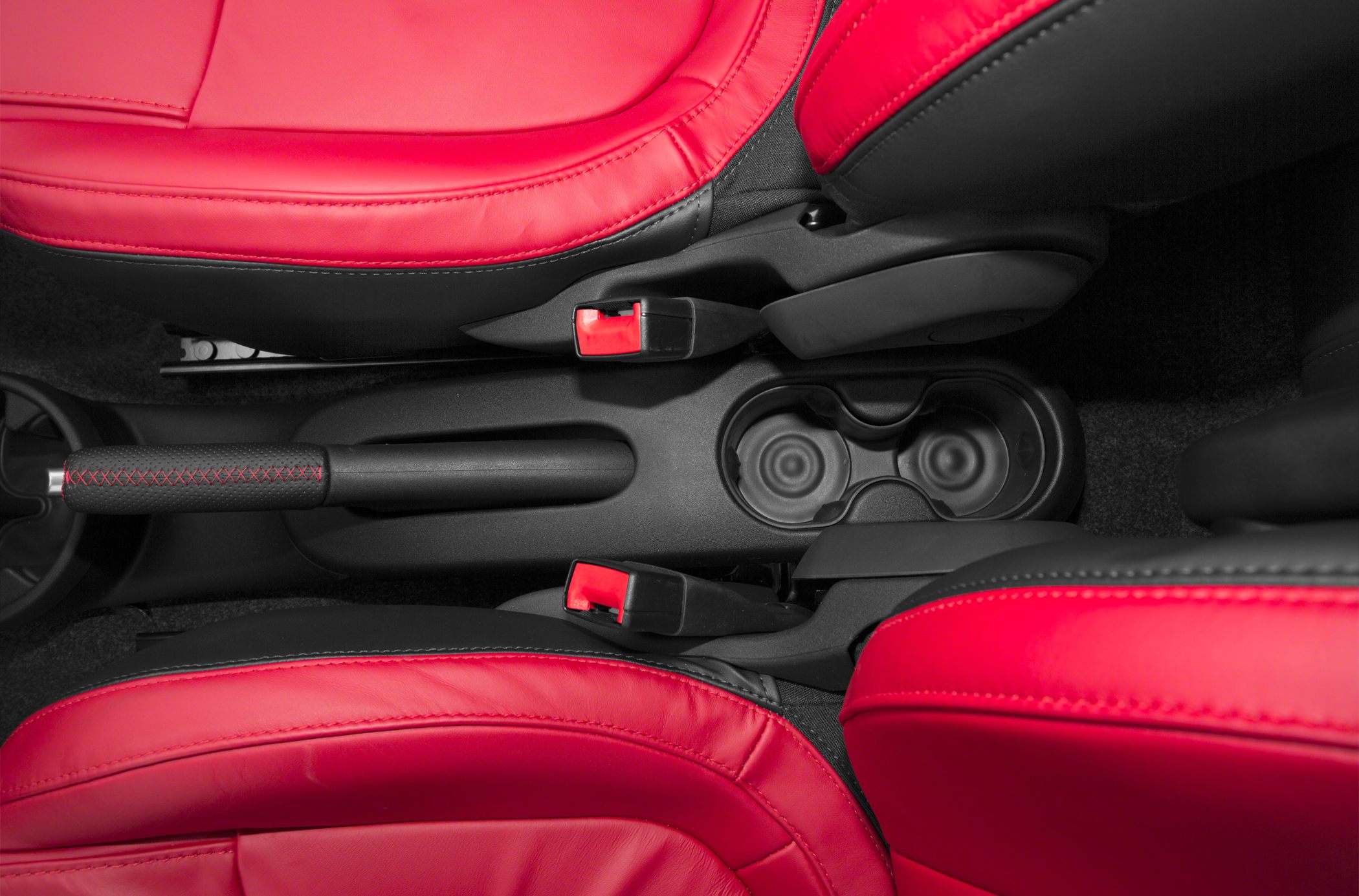 Red leather seats, handbrake and cup holders in car interior