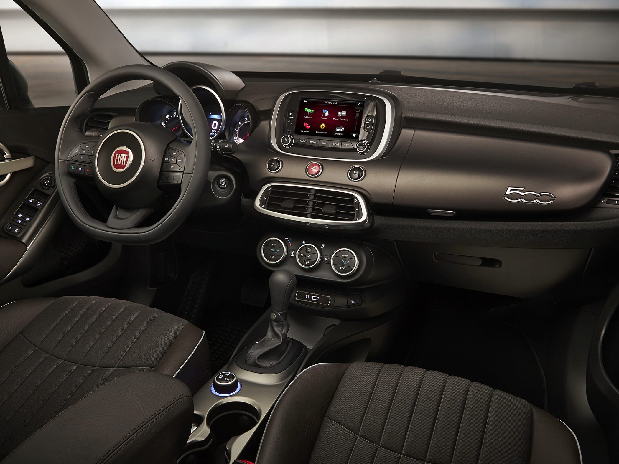 Interior with steering wheel, digital dashboard, touchscreen infotainment, and control dials