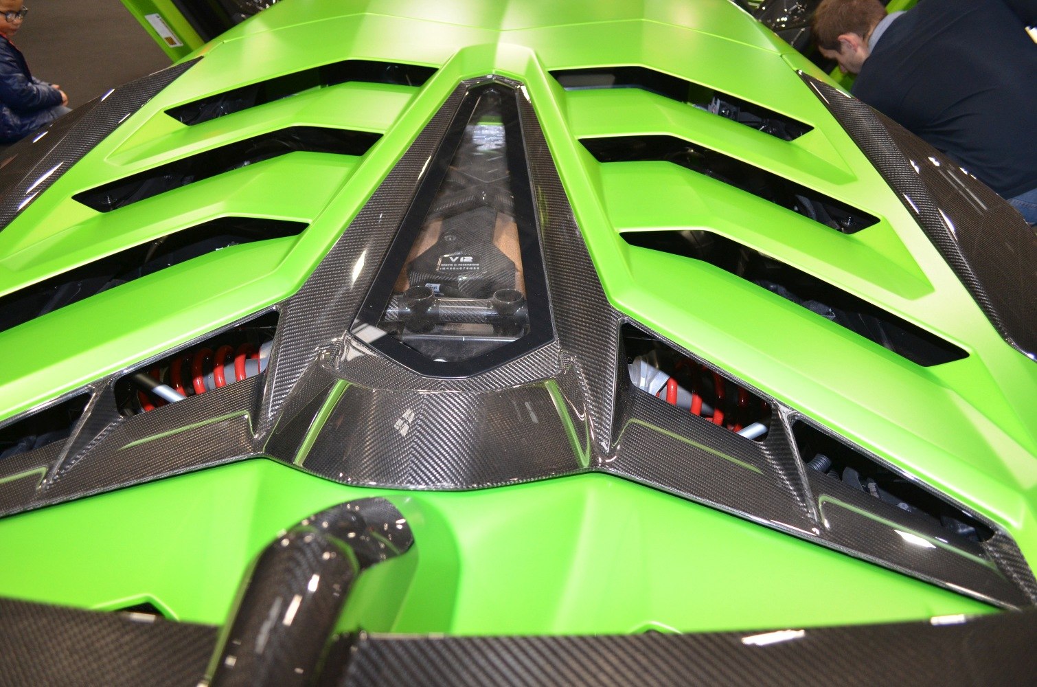 Close-up of green engine cover with carbon fiber and louvered vents