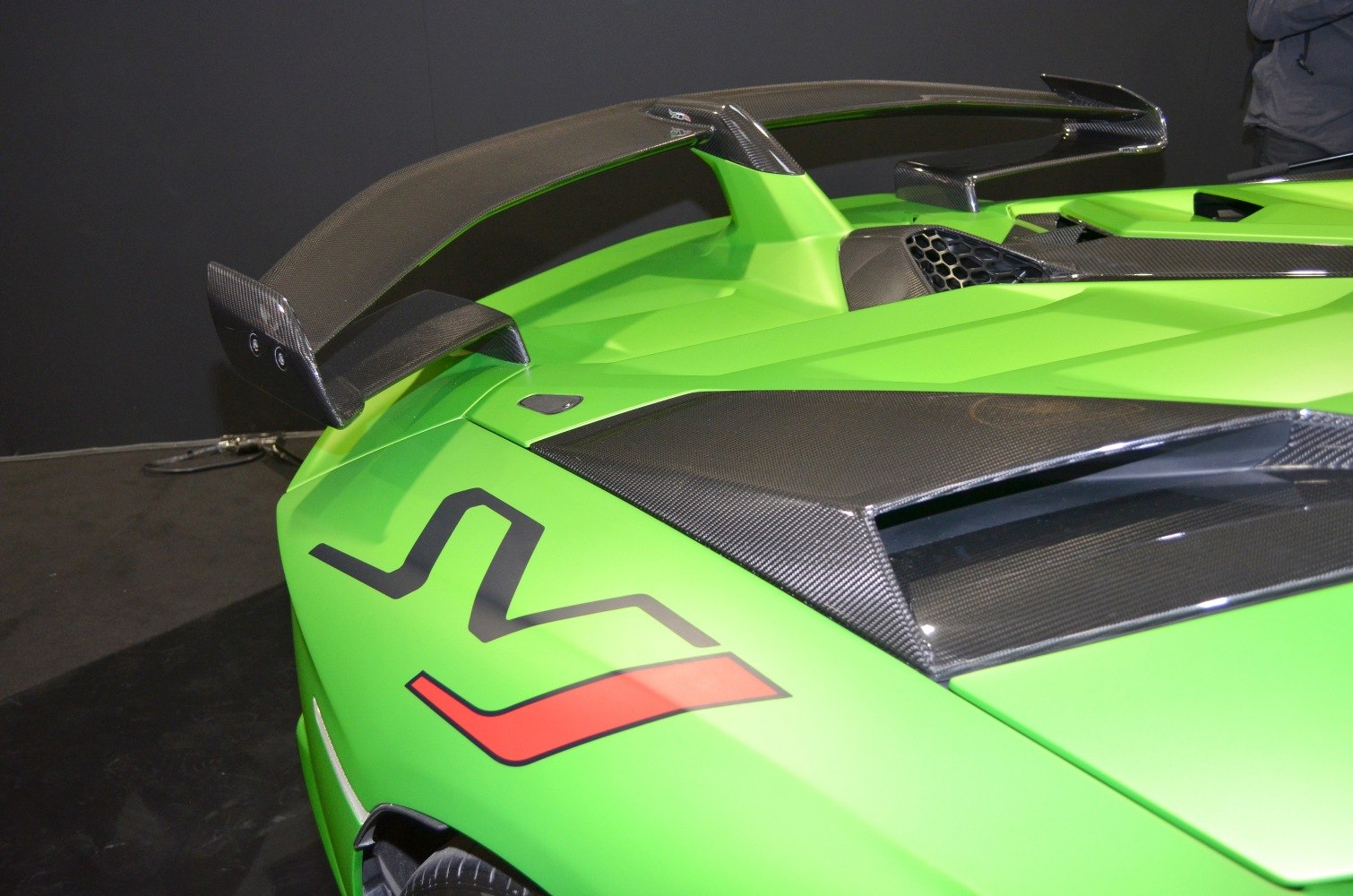 Carbon fiber rear wing and aerodynamic rear detailing on green sports car