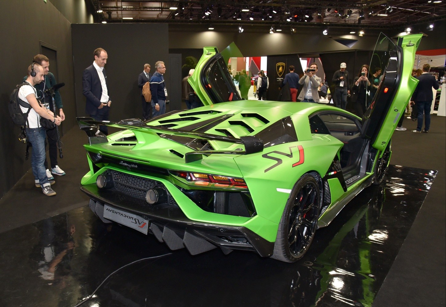 Aggressive rear spoiler and upward-opening scissor doors on a supercar.