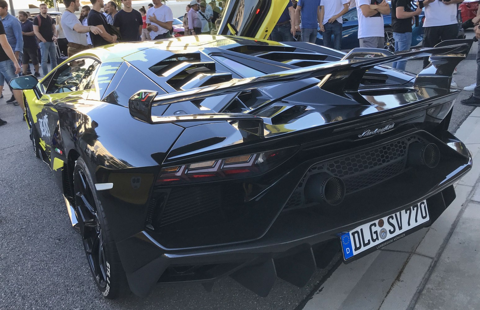 Rear view of supercar with large rear wing and distinctive taillights