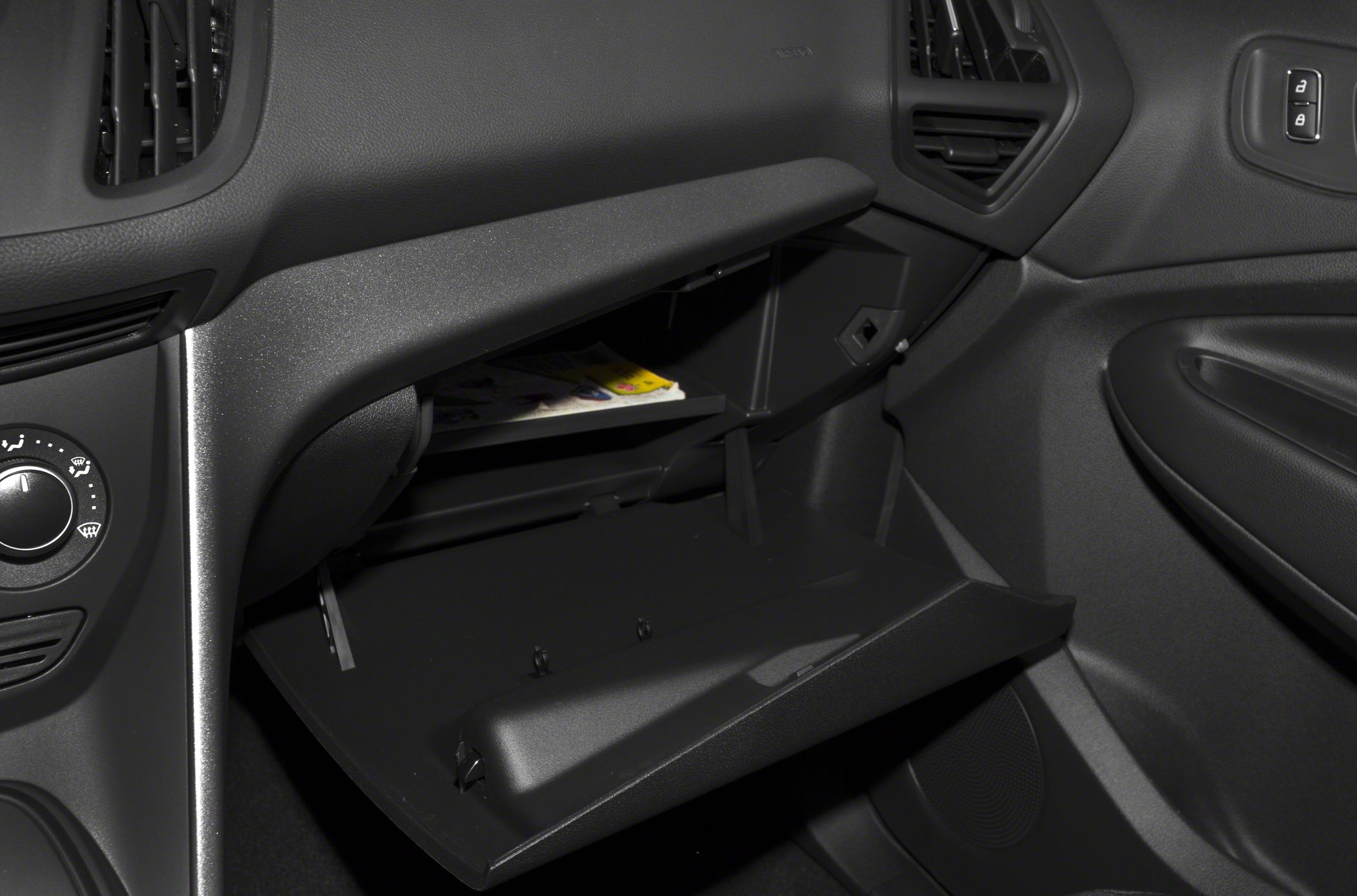 Open glove compartment and dashboard air vents in car interior