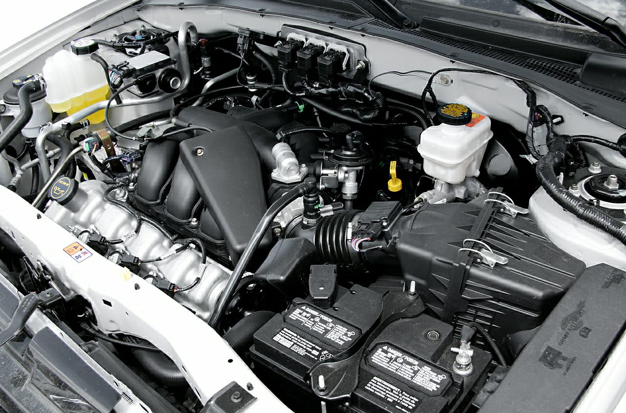 Close-up of car engine bay with detailed view of engine components and battery.