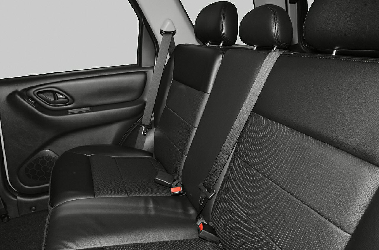 Rear seat with black leather upholstery and seat belts.