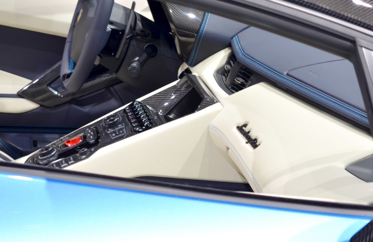 Luxury car interior with carbon fiber center console and stitch detailing