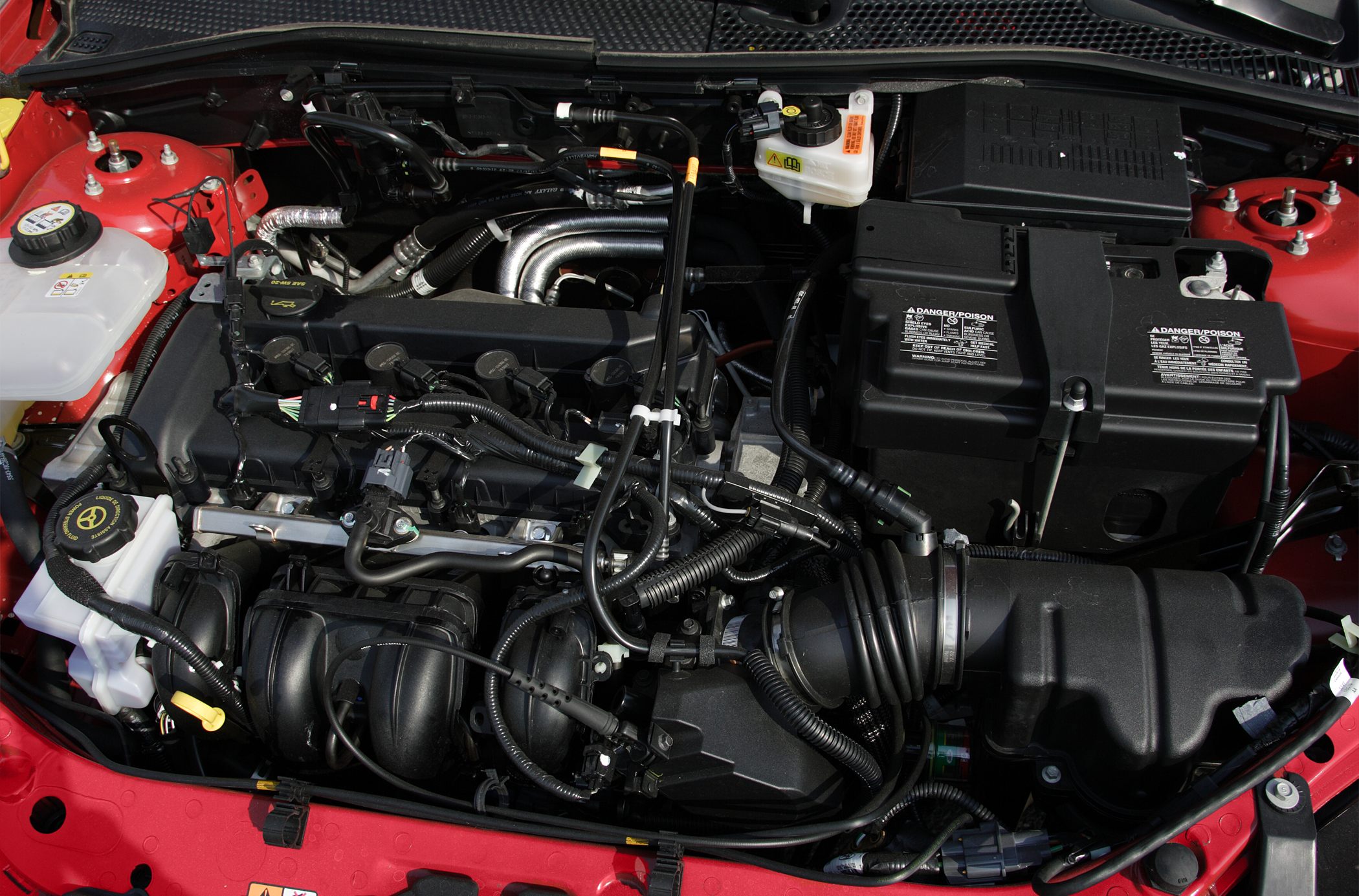 Clean and detailed view of a compact engine bay with hoses, wires, and reservoirs.