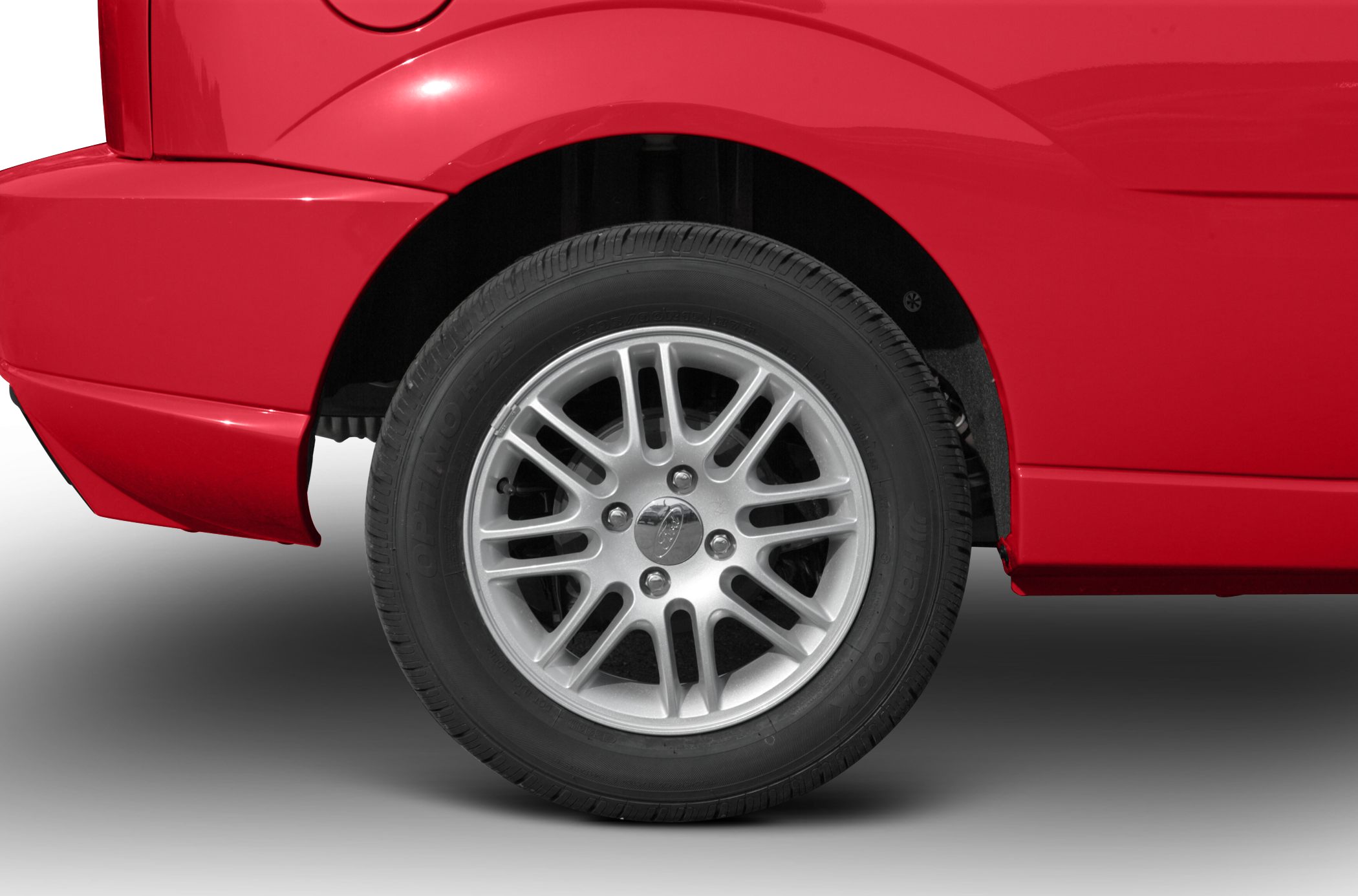 Rear alloy wheel and red hatchback body panel close-up