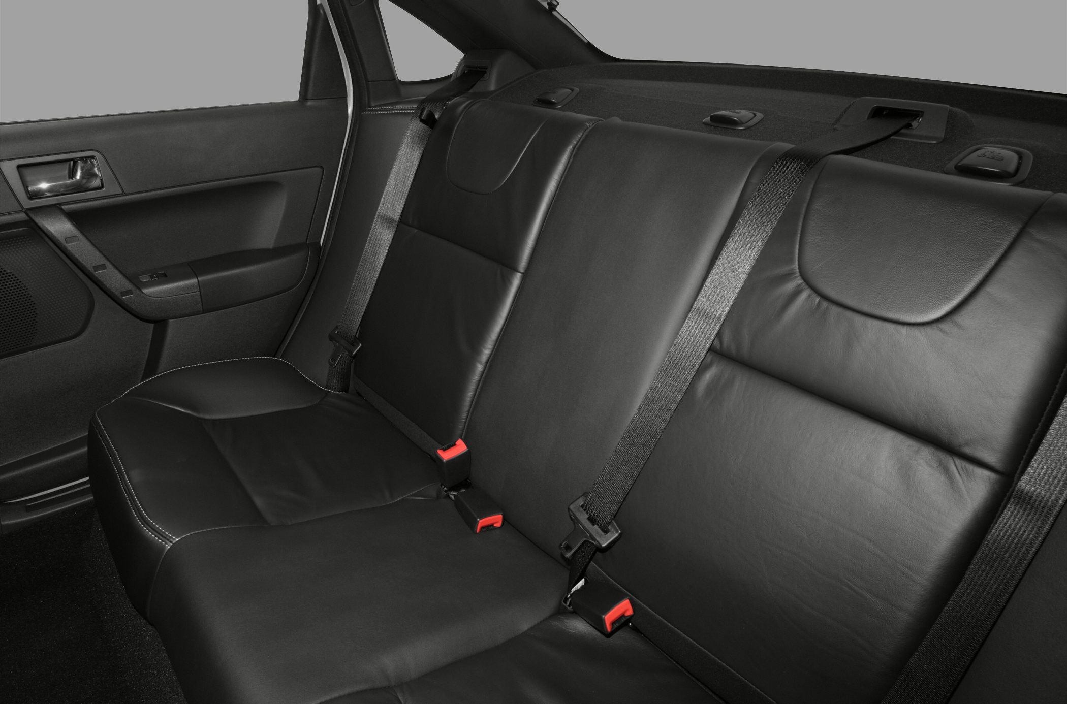 Rear seat black leather upholstery with seat belts and door panel.