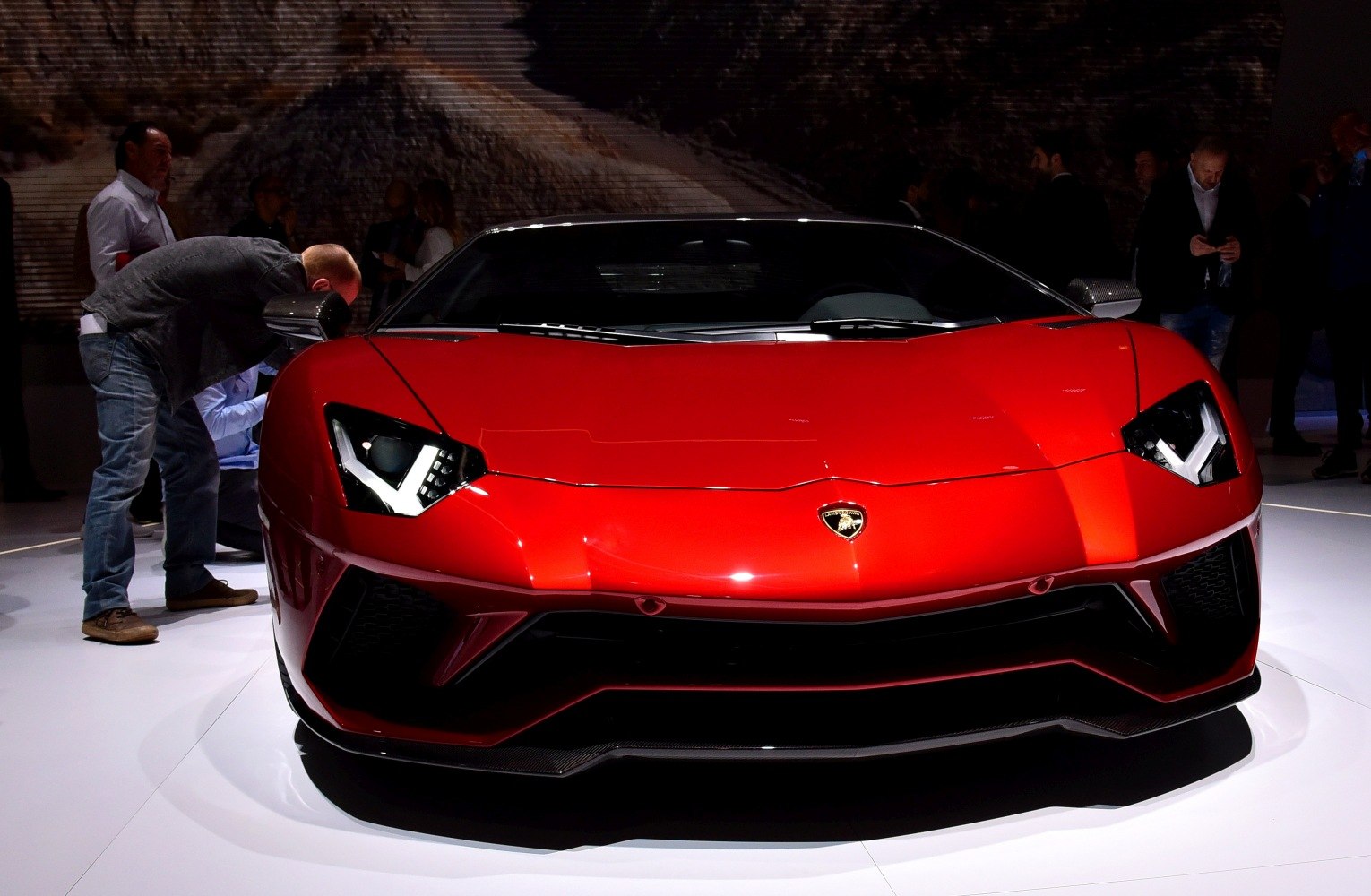 Red supercar front view with angular headlights and aerodynamic features.