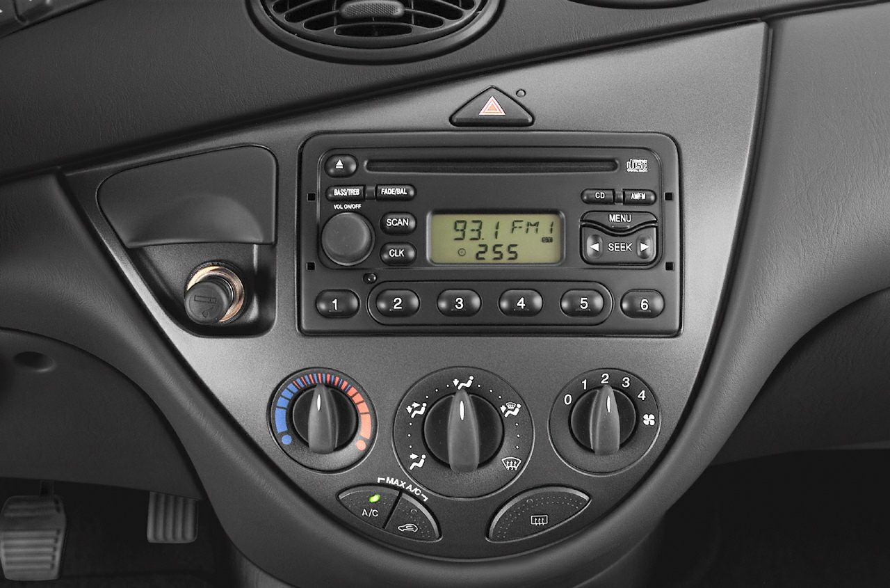 Car dashboard with radio, climate control knobs, and hazard light button