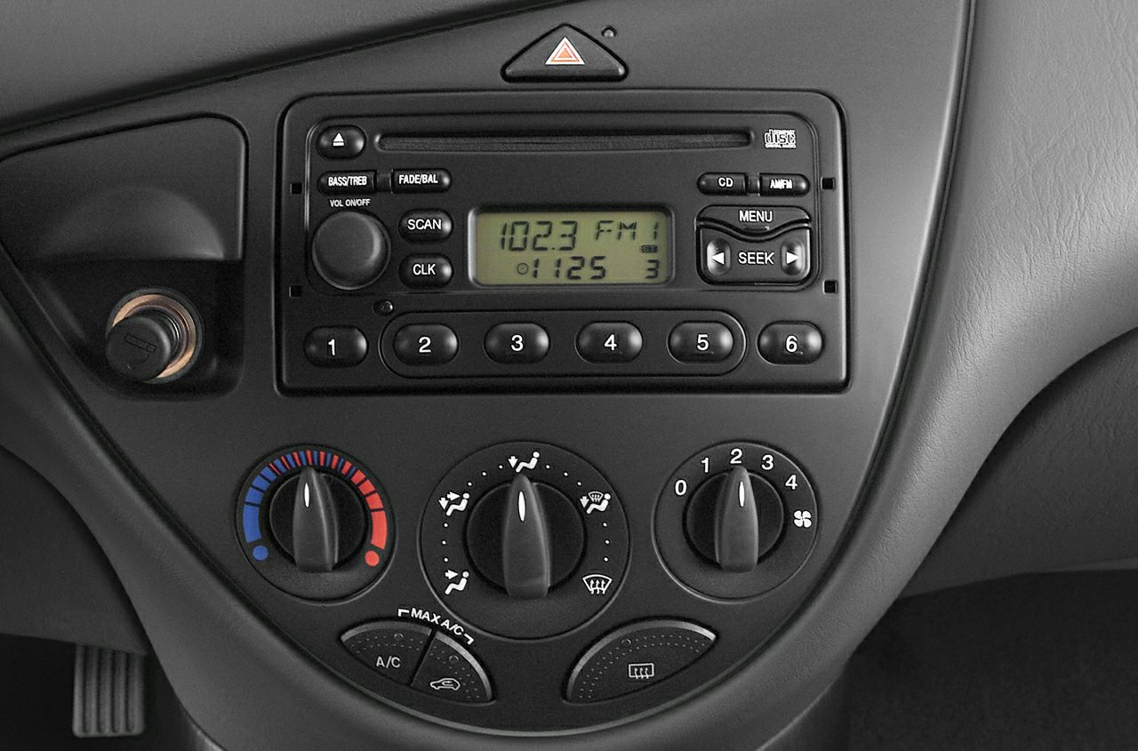 Car radio with preset buttons and manual climate control knobs.