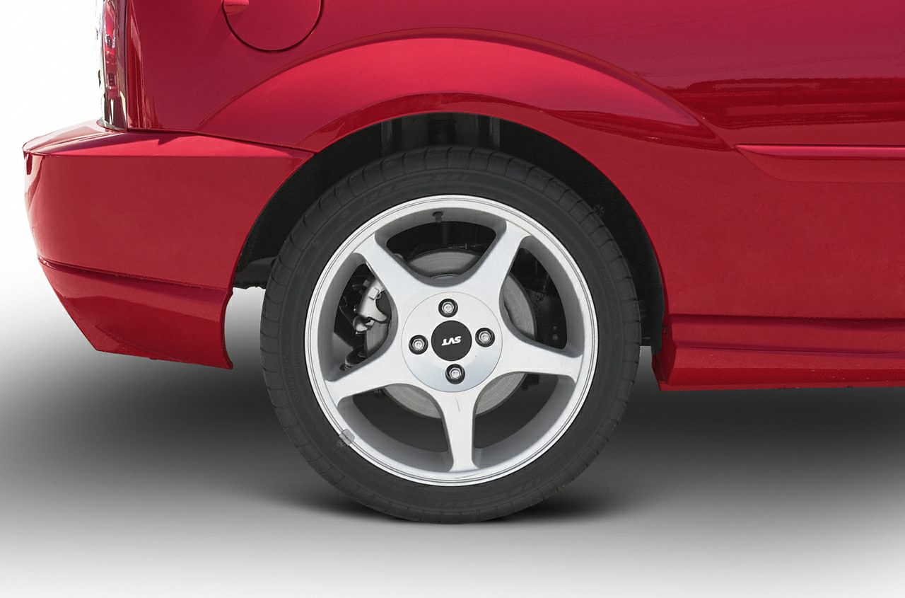 Rear wheel with five-spoke alloy rim and brake disc on red hatchback