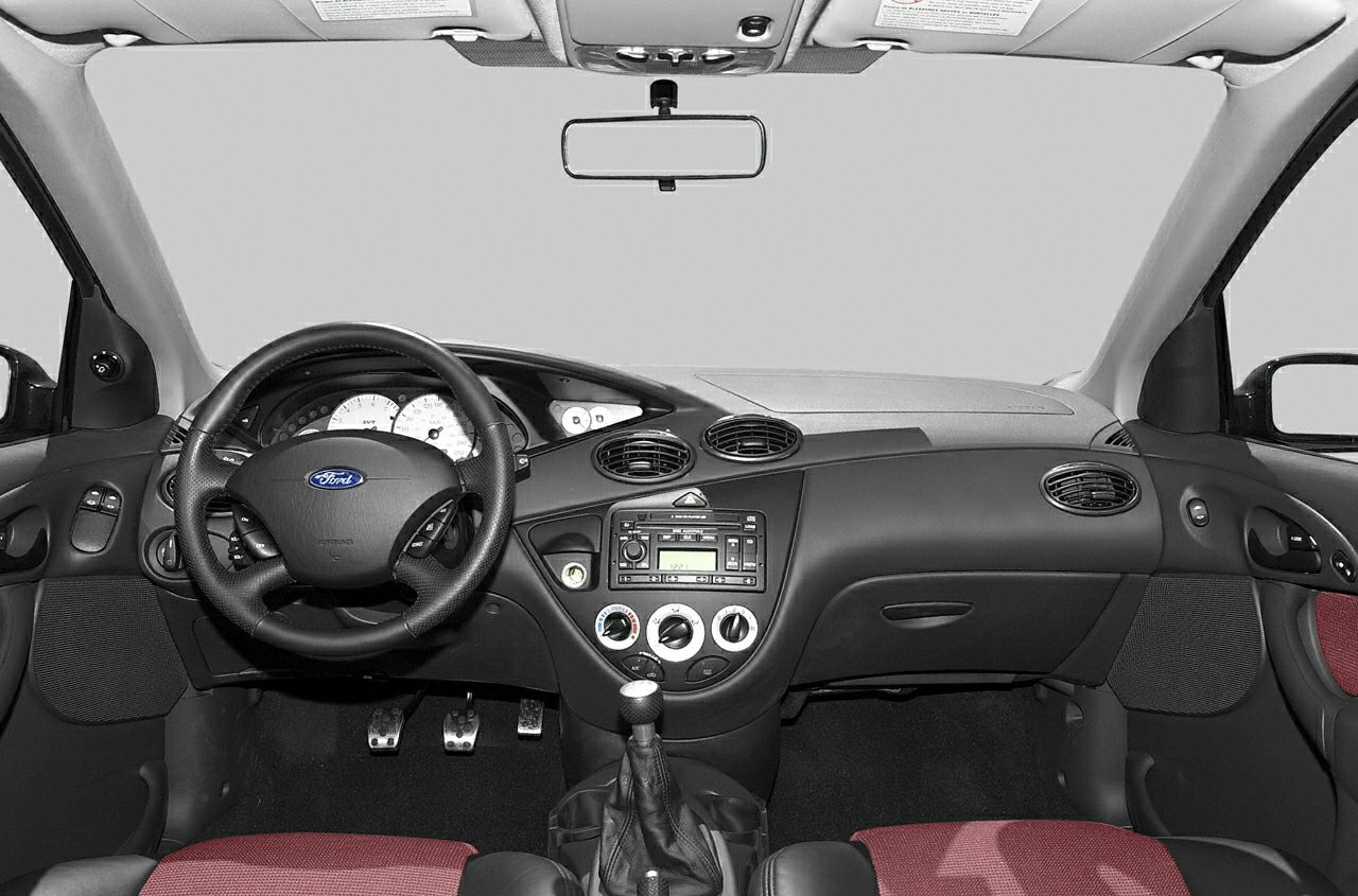 Steering wheel, dashboard with circular air vents, manual gear shift.