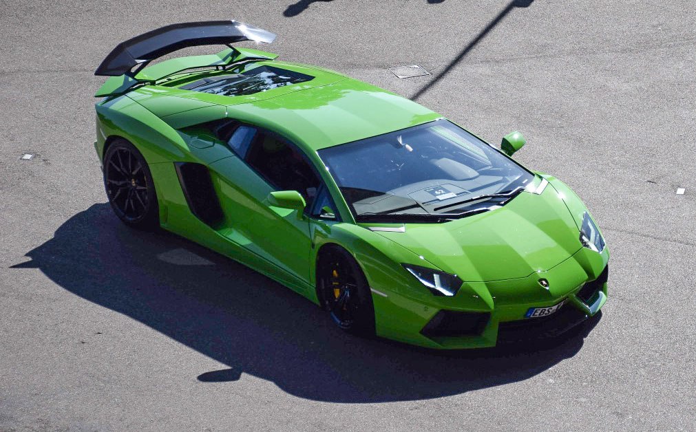 Green sports coupe with raised aerodynamic rear spoiler and angular headlights
