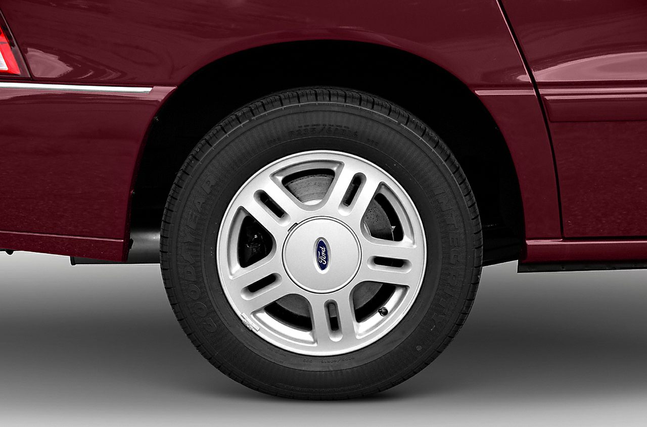 Close-up of aluminum alloy wheel and tire on vehicle side panel.
