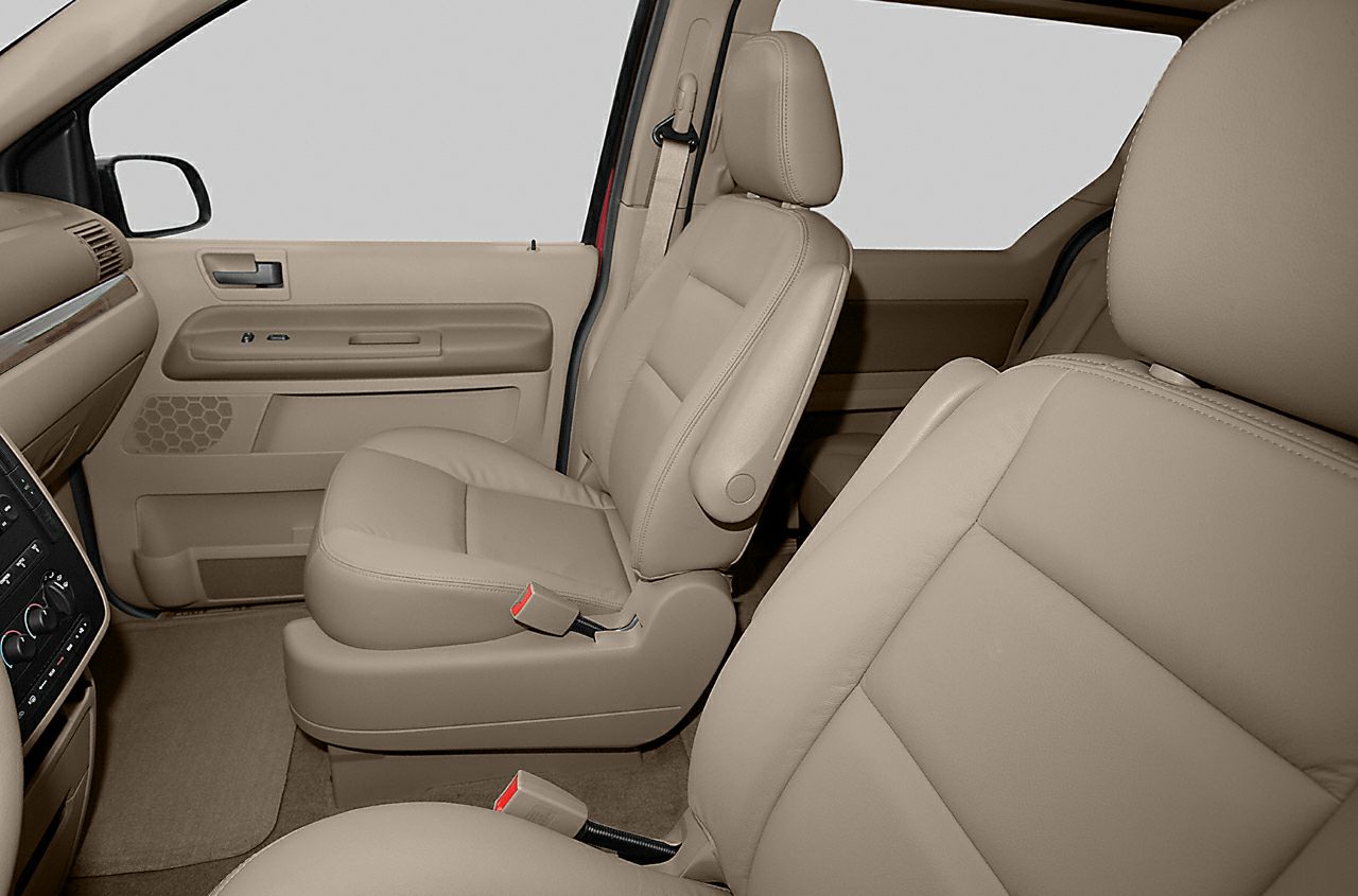 Beige leather front seats and door panel with seatbelt in vehicle interior