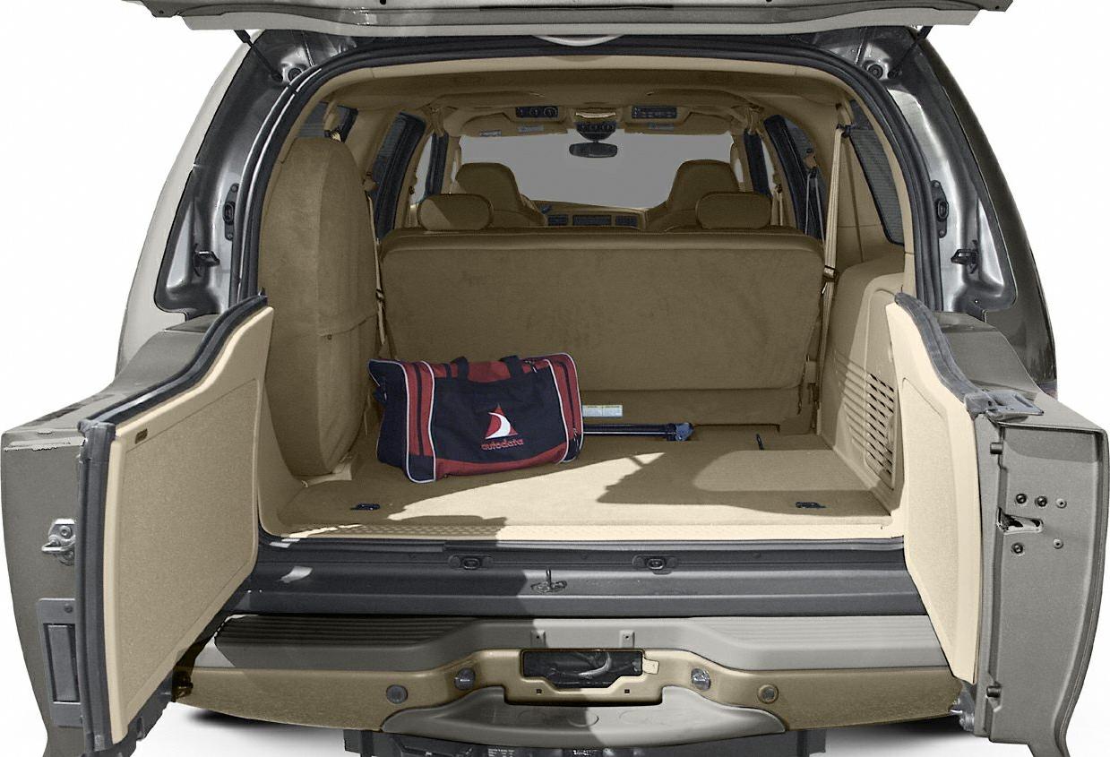 Wide rear cargo space with open doors and beige interior upholstery