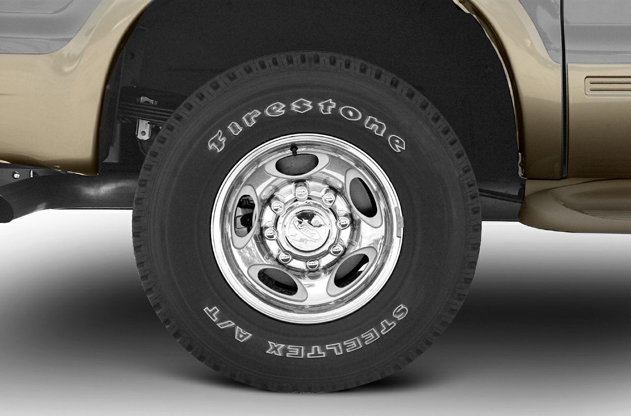 Chrome rim and Firestone Steeltex A/T tire on large SUV wheel