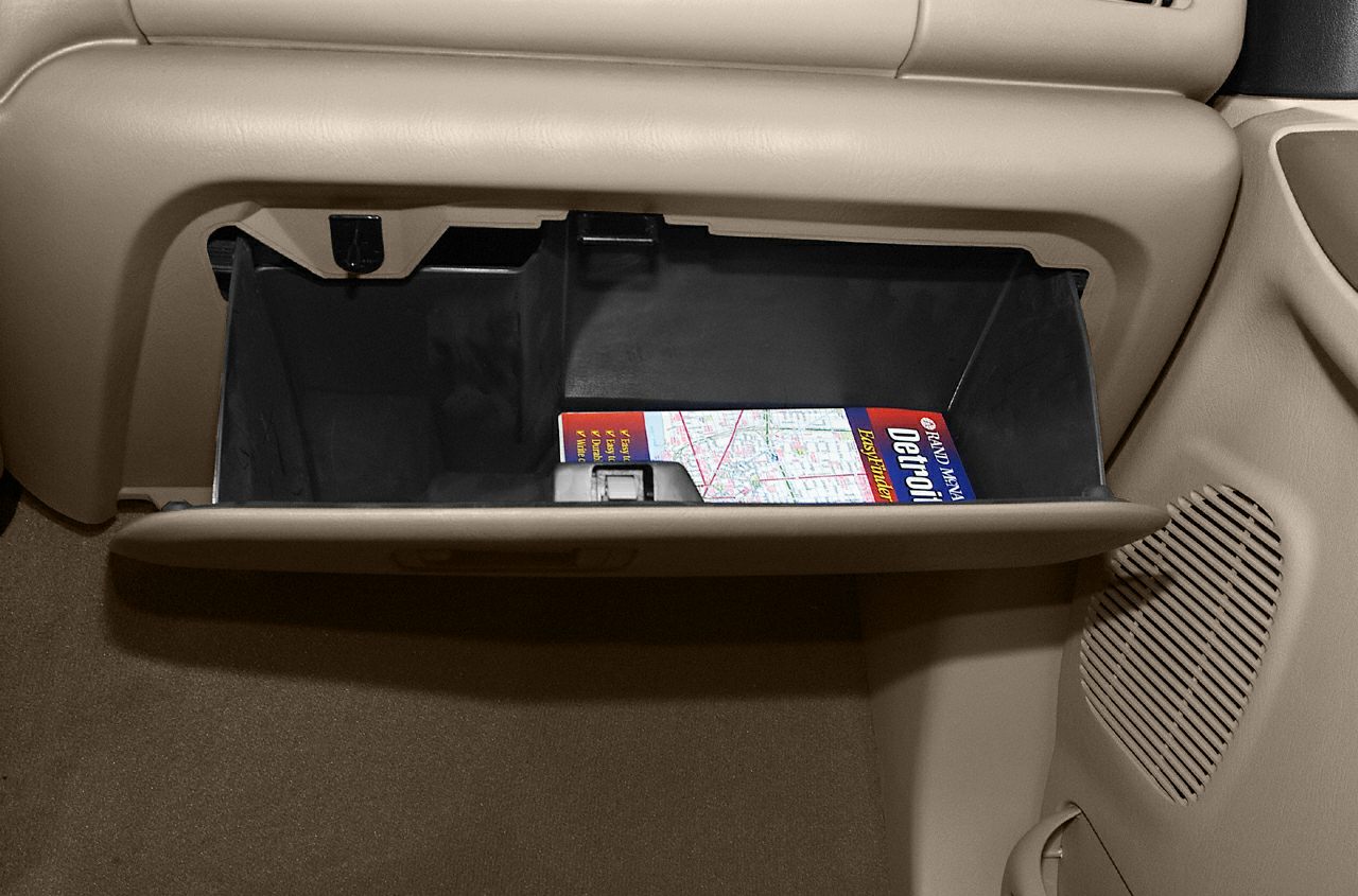 Open glove box with a map inside, beige interior trim