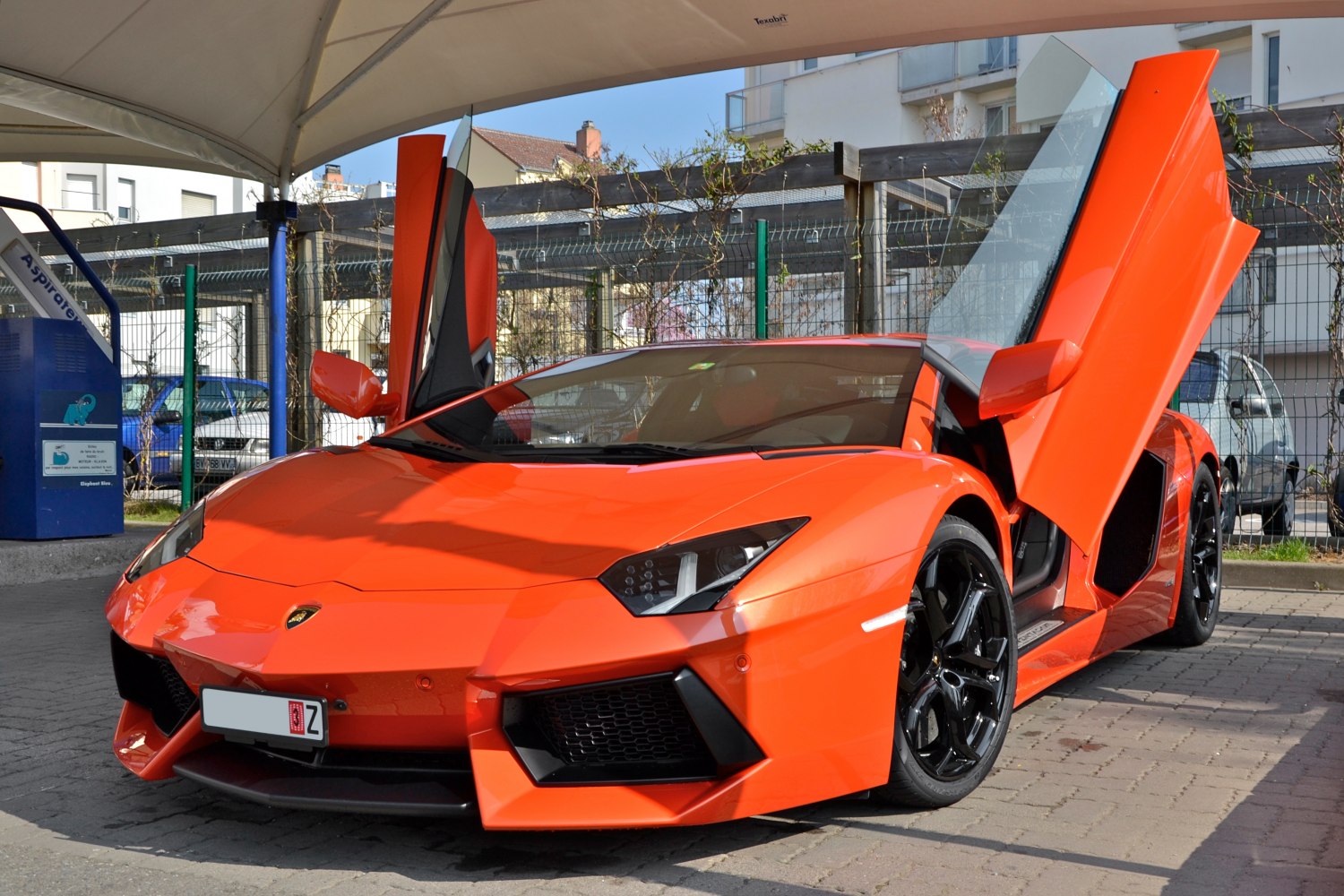 Orange supercar with distinctive upward-opening scissor doors