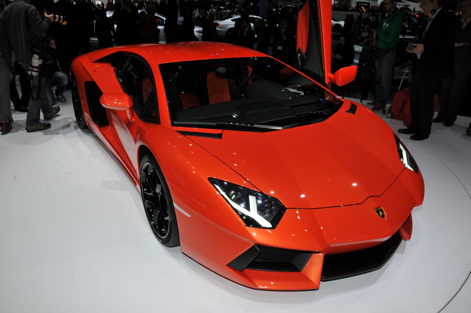 Red sports car front with angular headlights and scissor door open