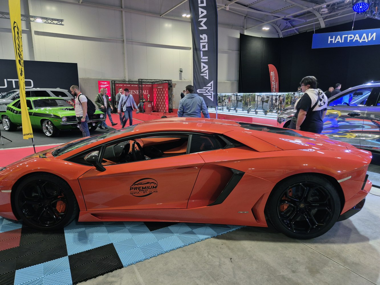 Side profile of an orange sports coupe with black wheels.