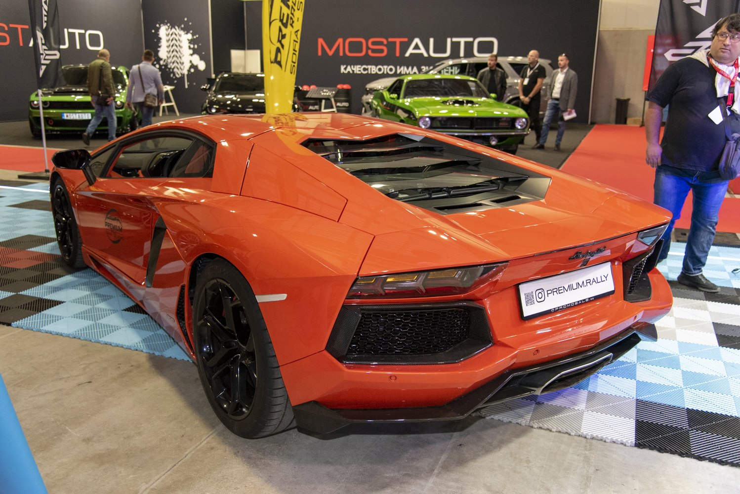 Rear view of an orange supercar with angular vents and black wheels